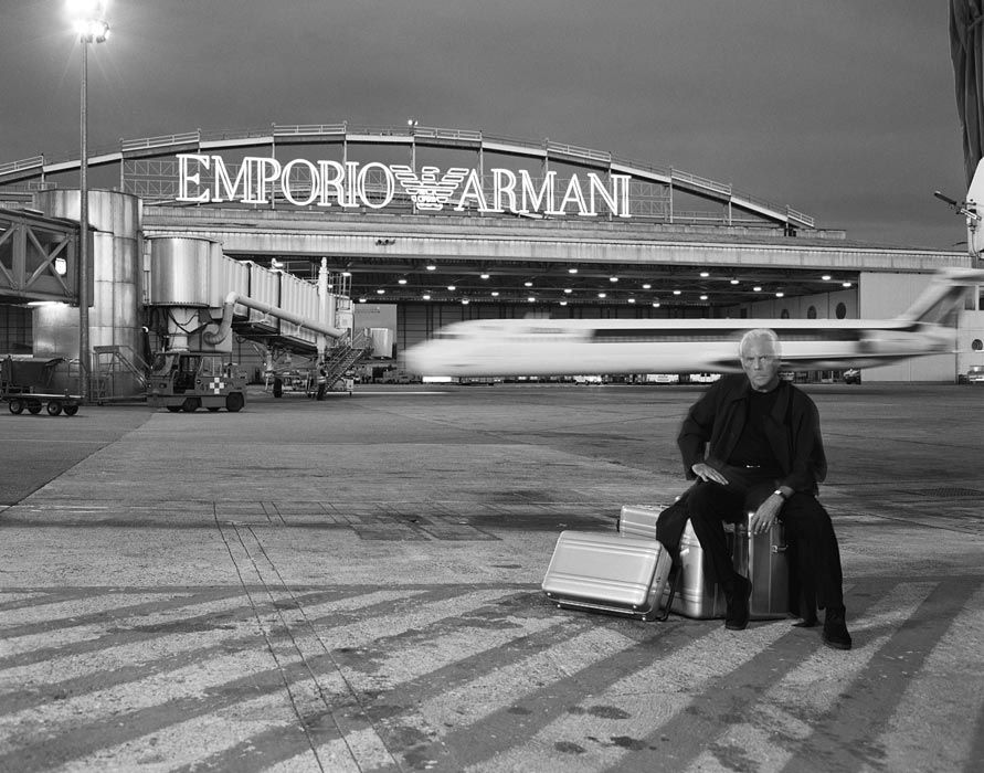 Giorgio Armani davanti all'hangar di Linate con la scritta di Emporio Armani